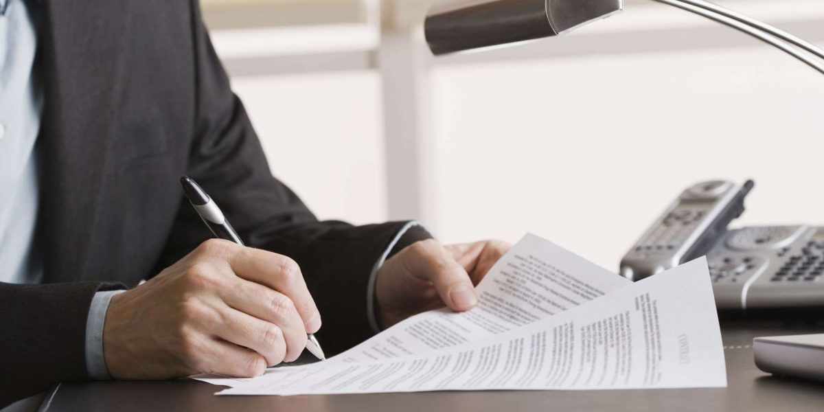 Person writing on paper documents